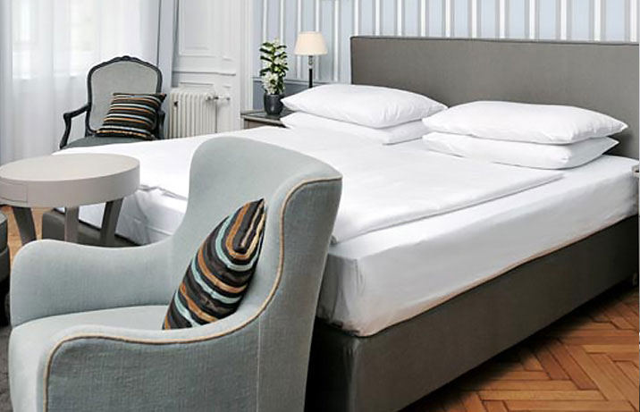 Double room at the Hotel Kärntnerhof Vienna with a bed and two armchairs