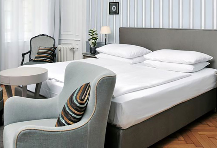 Triple room at the Hotel Kärntnerhof with a bed and two armchairs