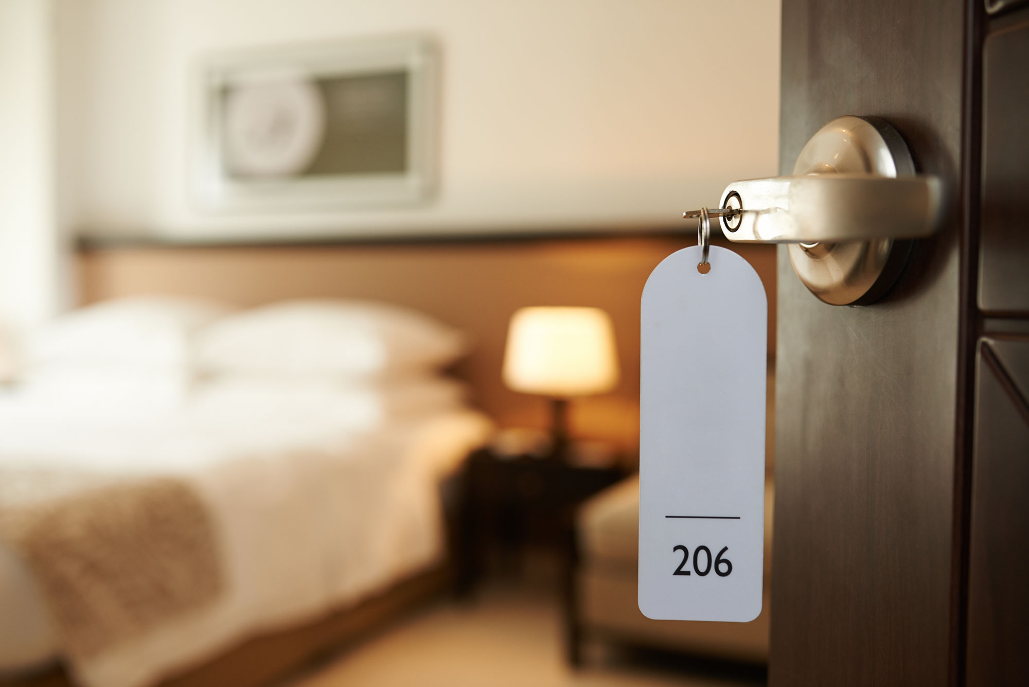 Porta della camera con il numero della stanza e il letto all’Hotel Kärntnerhof di Vienna
