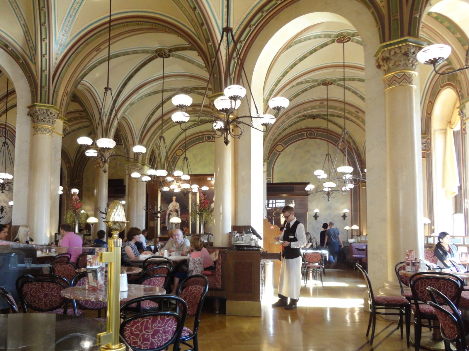 Säulenhalle des Café Central in Wien mit Marmortischen, Thonetstühlen und Gästen