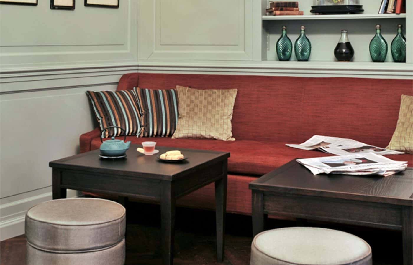 Rote Sitzbank im Salon des Hotel Kärntnerhof mit Zeitungen und Teekanne