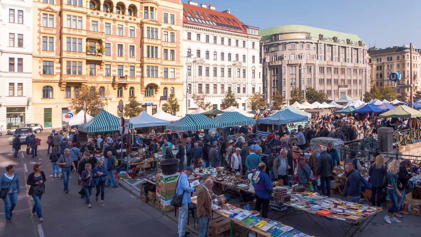 Flohmarktstände mit Trödel und Besuchern neben dem Wiener Naschmarkt