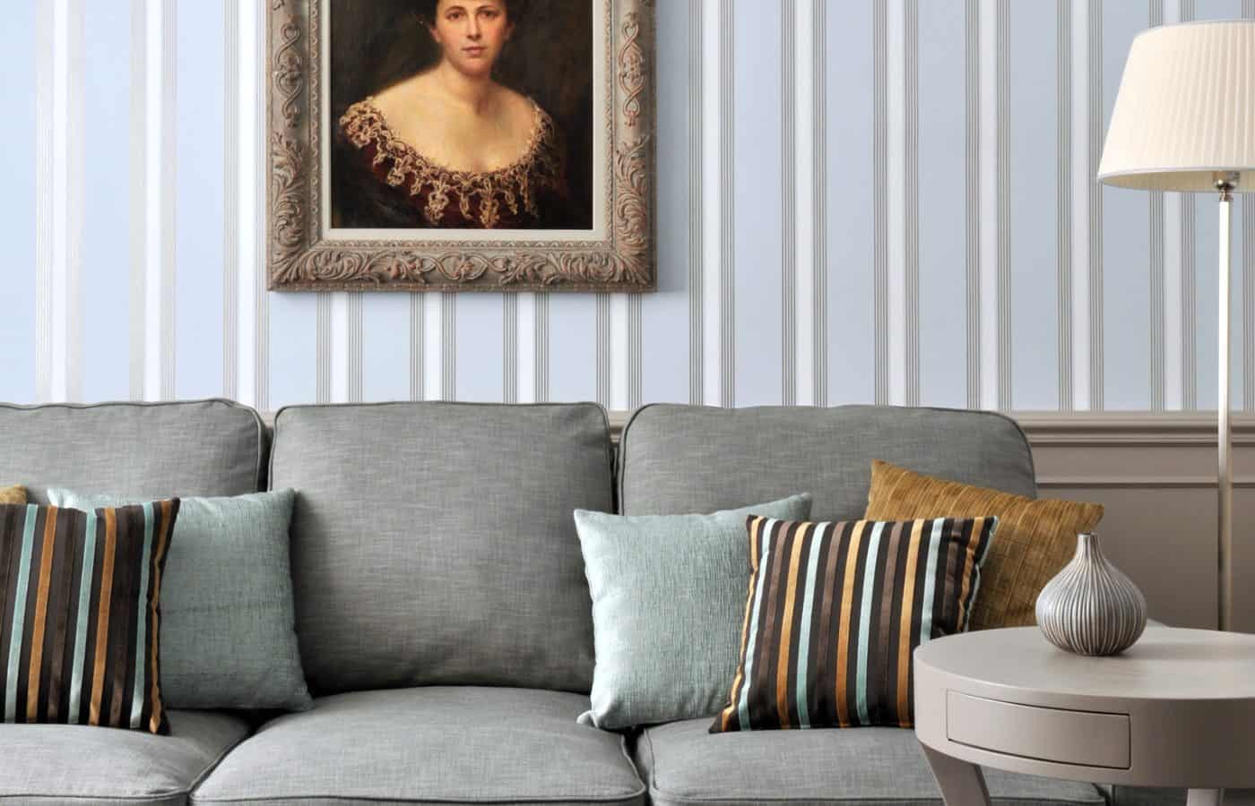 Salon einer Suite im Hotel Kärntnerhof mit grauem Sofa unter einem Damenporträt