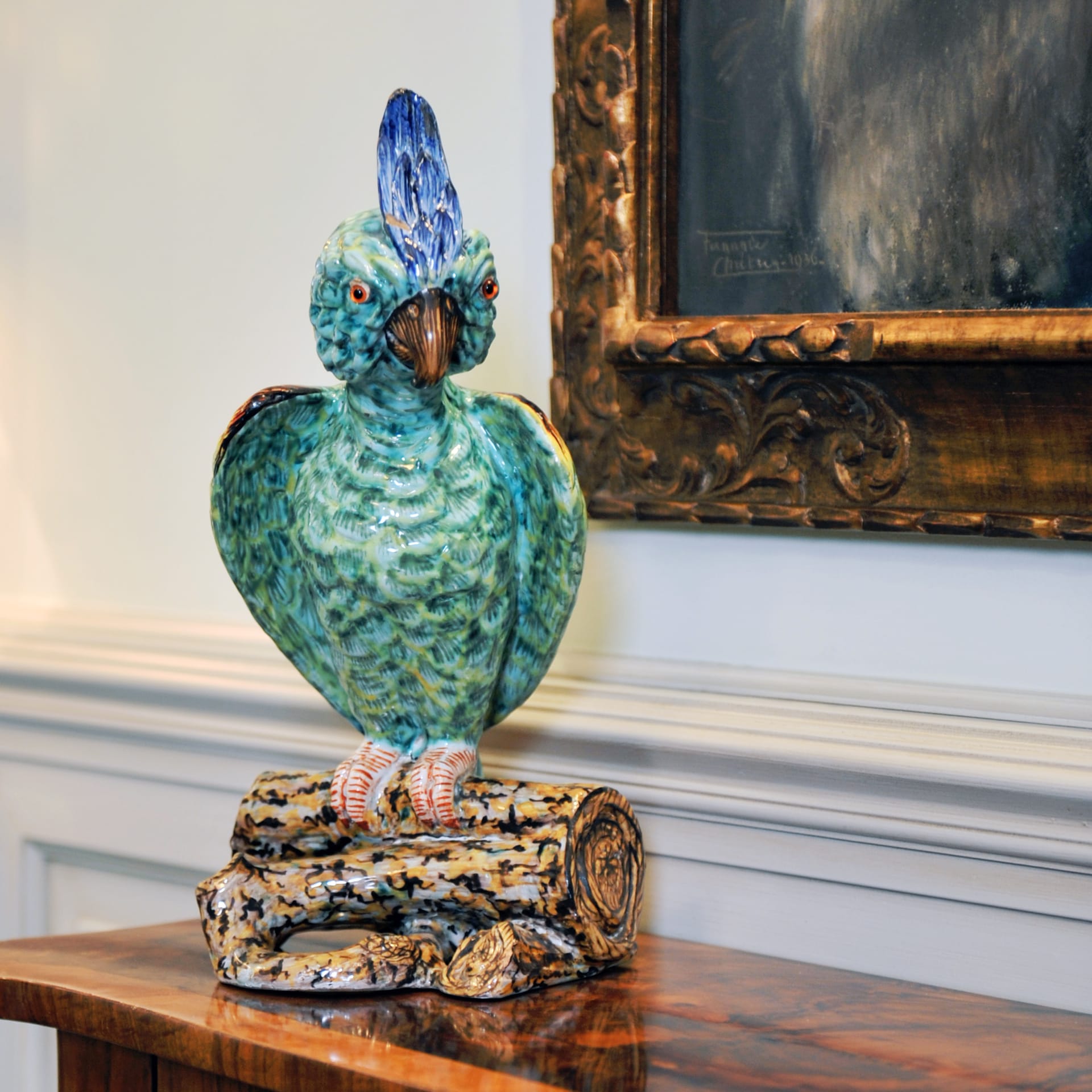 Keramikfigur eines Papageis auf einer Biedermeier-Kommode im Hotel Kärntnerhof, dahinter ein goldgerahmtes Gemälde